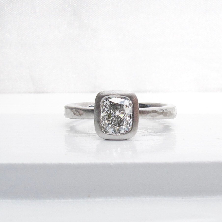 Platinum and cushion cut diamond tapered band solitaire low profile bezel set engagement ring