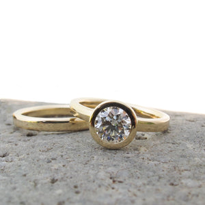 Classic gold and diamond bezel set engagement with gold wedding bands