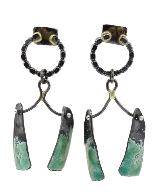 Pair of earrings with green and black design on a white background