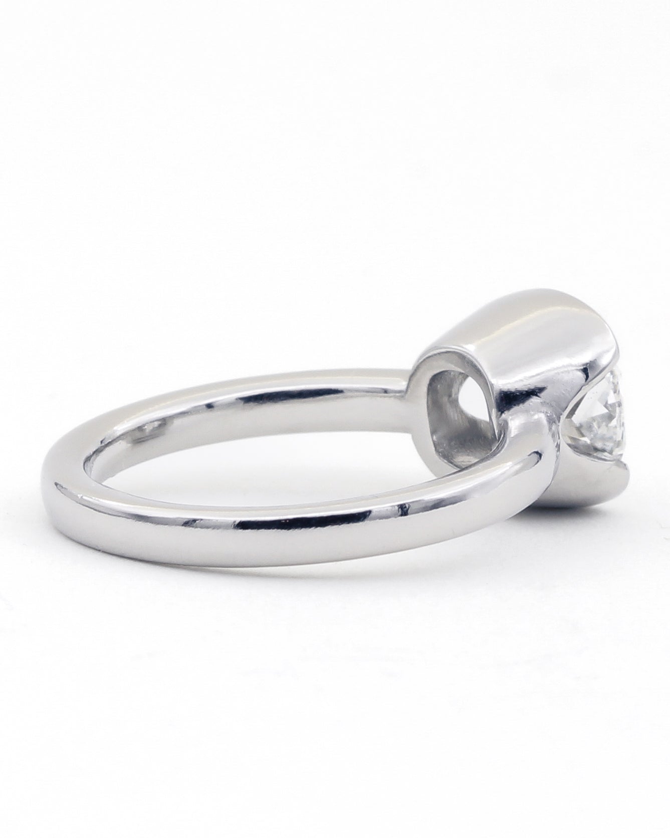 Profile view of patinum ring with a diamond on a white background
