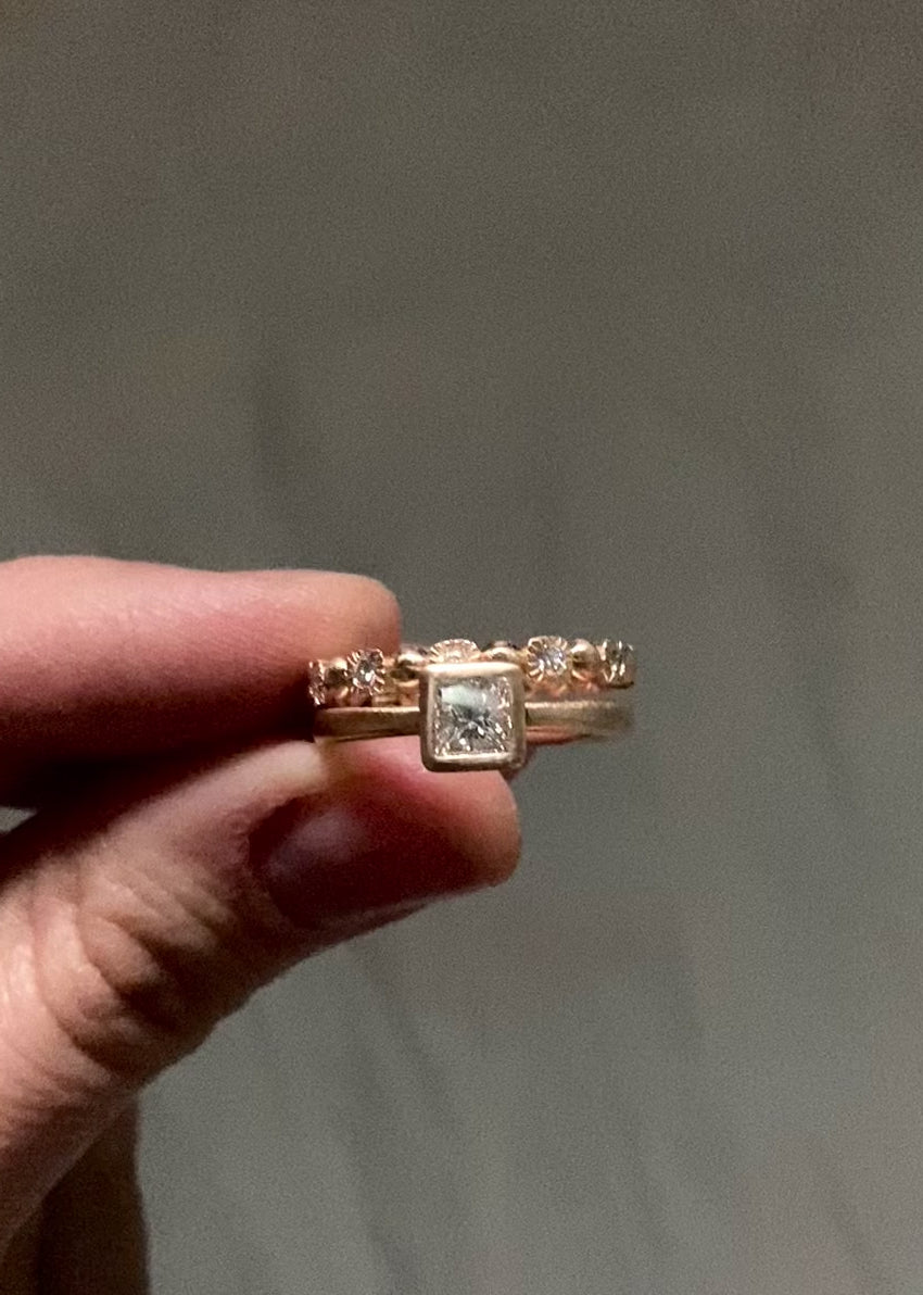 Princess diamond engagment ring stacked with a rose gold eternity band