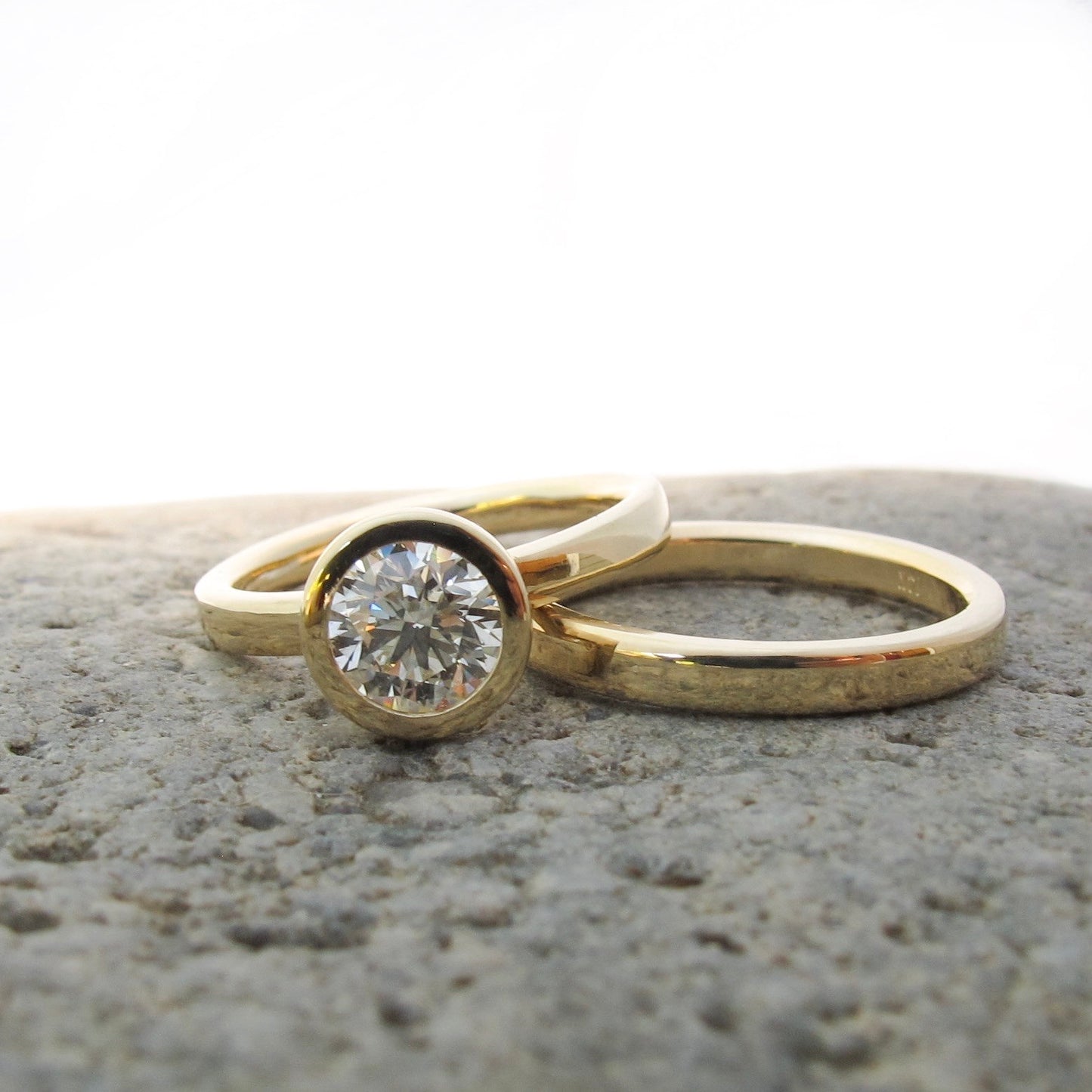 Classic gold and diamond bezel set engagement with gold wedding bands