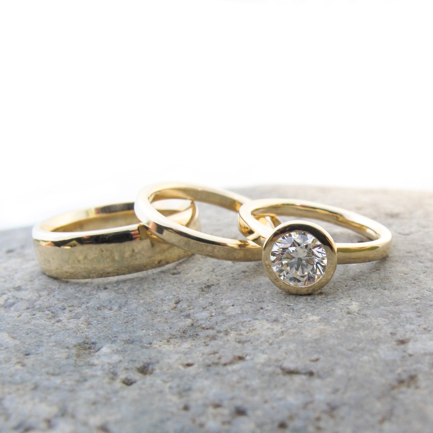 Classic gold and diamond bezel set engagement with gold wedding bands