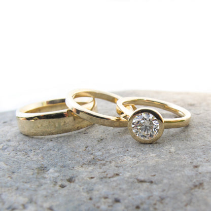 Classic gold and diamond bezel set engagement with gold wedding bands