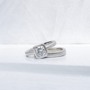 Platinum and cushion cut diamond tapered band solitaire low profile bezel set engagement ring